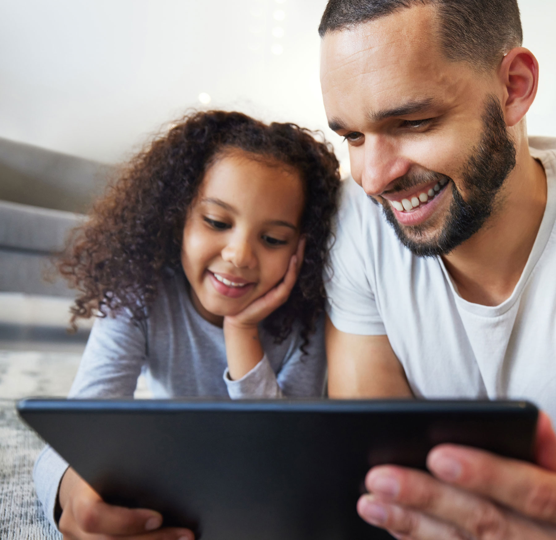 father and daughter looking at tablet